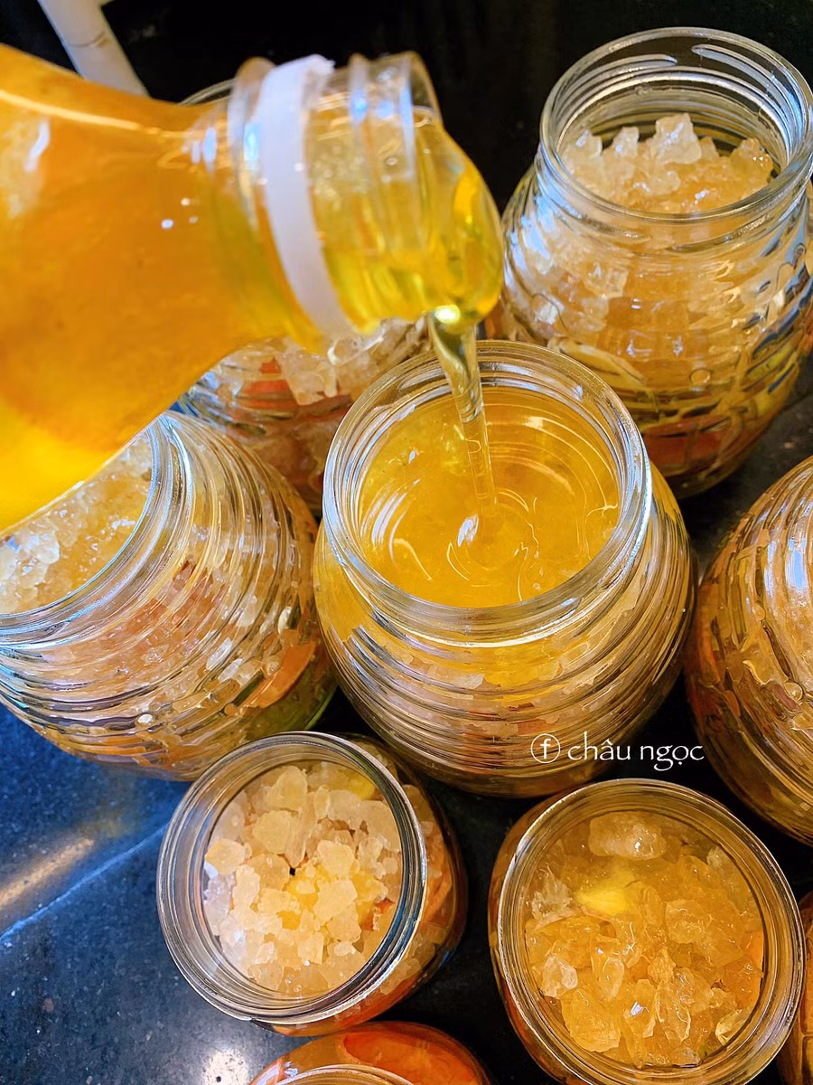 Cho tiếp đường phèn lên. Đường càng to thì tan lâu và có thể thay thế dụng cụ chèn. Sau đó rót mật vào từ từ, đảm bảo chỉ đầy 2/3 hũ ngâm.