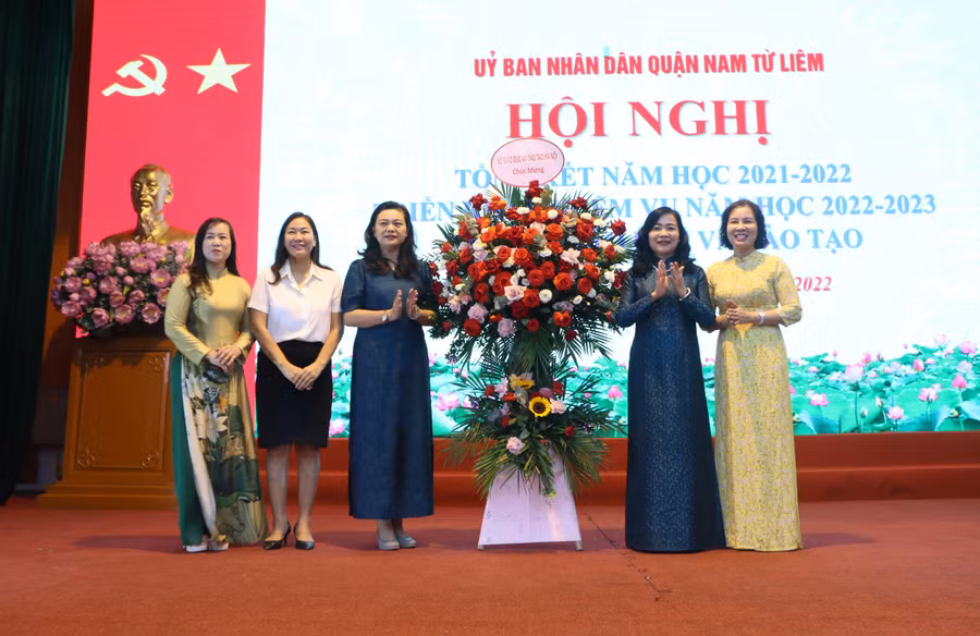 Phó Giám đốc Sở GD&ĐT Hà Nội Trần Lưu Hoa (thứ 3 từ trái sang) tặng hoa chúc mừng thành tích của ngành GD&ĐT quận Nam Từ Liêm.