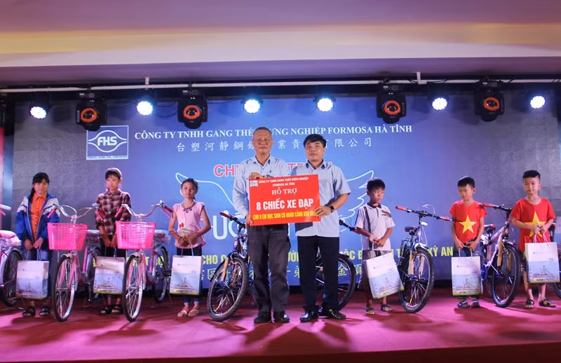 Ông Ngưu Tuấn Phát -Trưởng BQL dự án của Formosa Hà Tĩnh (bên trái) và ông Hoàng Thanh Tùng, Phó trưởng Ban khu kinh tế Hà Tĩnh (bên phải) trao xe đạp cho học sinh nghèo tại thị xã Kỳ Anh.