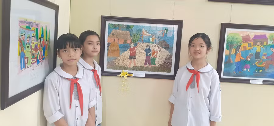 Các em học sinh trường tiểu học TT Tân An bên bức tranh đạt giải “Chiều trên quê hương”