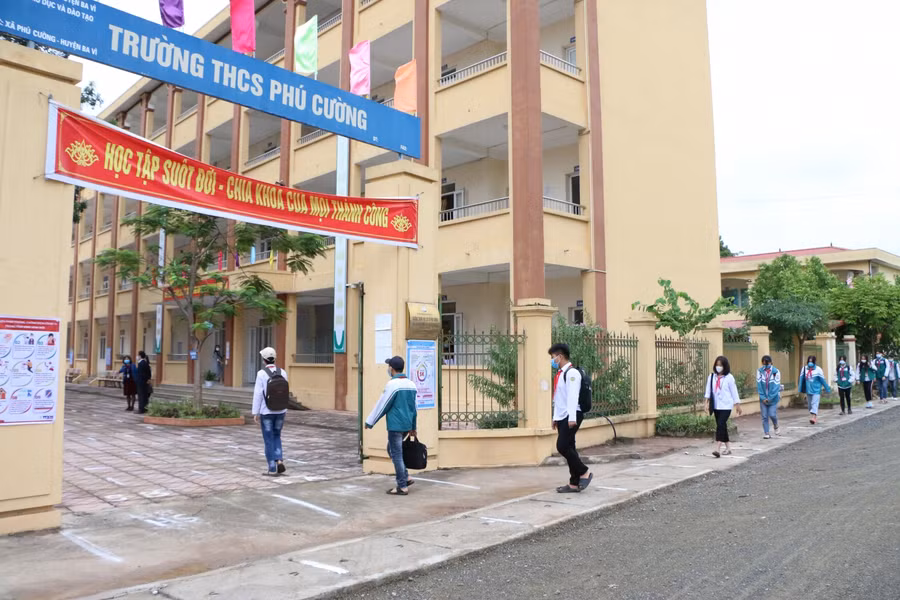 Học sinh Trường THCS Phú Cường xếp thành hàng giãn cách từ cổng trường trong sáng 8/11.