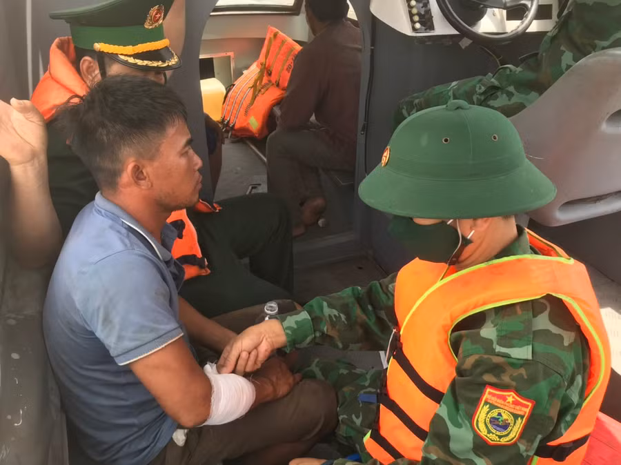 Bộ đội Biên phòng kiểm tra, sơ cứu thuyền viên bị thương. (Ảnh: Nguyễn Thế Cương)