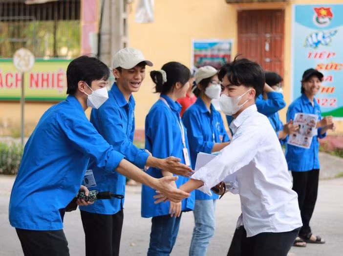 Tình nguyện viên chúc mừng thí sinh hoàn thành bài thi tại Điểm thi trường THPT Lục Nam.