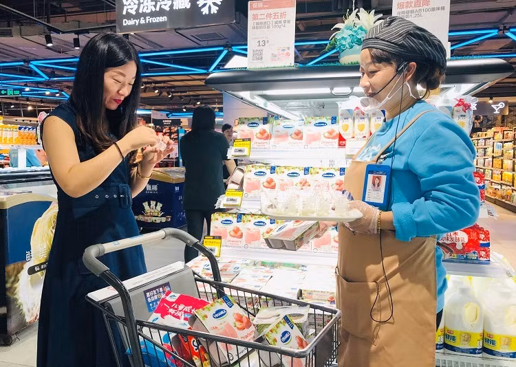 Một người dùng đang thử sữa chua Vinamilk tại siêu thị Hema.