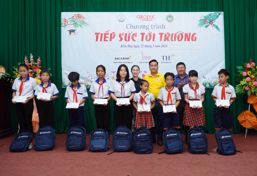 Ông Nguyễn Thanh Sơn - Giám đốc Công ty Sách thiết bị trường học TP Cần Thơ và bà Trần Thị Yến Oanh, Phó Chủ tịch UBND xã An Sơn trao học bổng và quà. Ảnh: Mạnh Tùng.