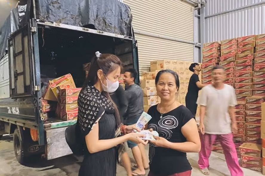 Ca sĩ Thủy Tiên trực tiếp lội nước ngập phát lương thực cho dân 