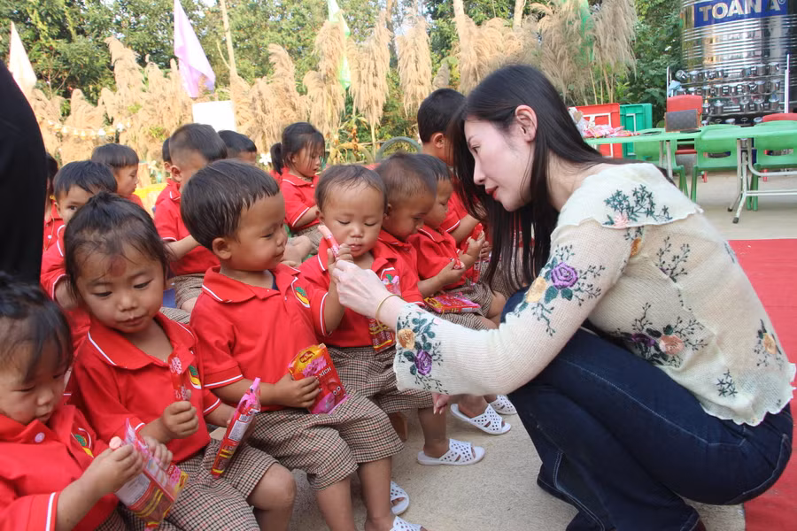 Những đứa trẻ thích thú với những chiếc xúc xích được tặng.
