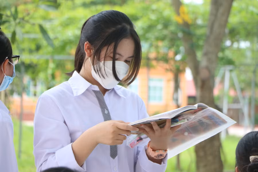 Nhiều thí sinh tranh thủ đọc lại bài trước khi đến giờ được giám thị gọi vào phòng thi.