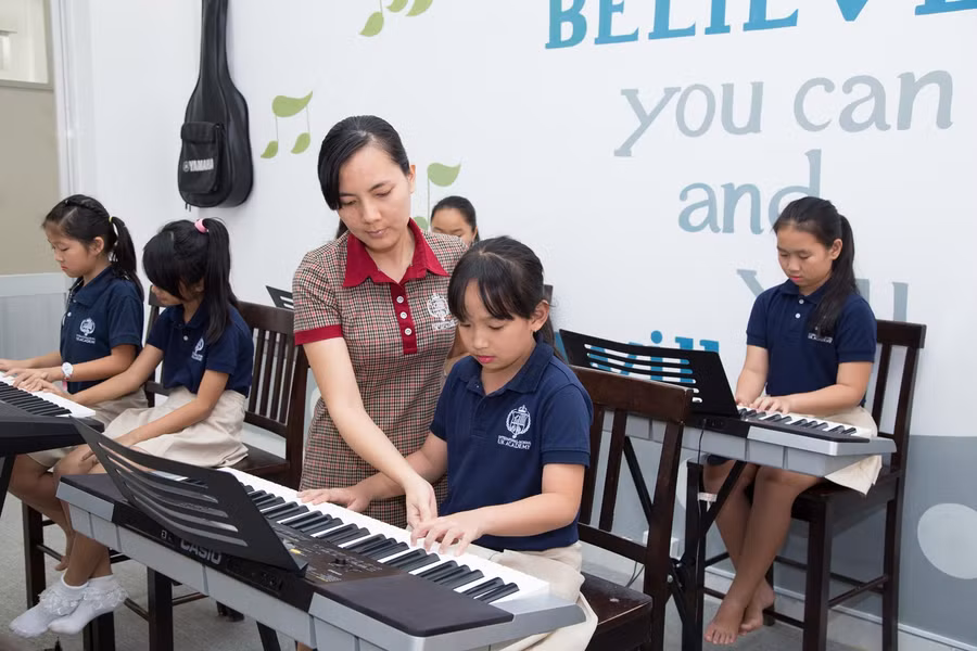 Học sinh của hệ thống NHG đang học nhạc cùng giáo viên Học sinh của hệ thống NHG đang học nhạc cùng giáo viên