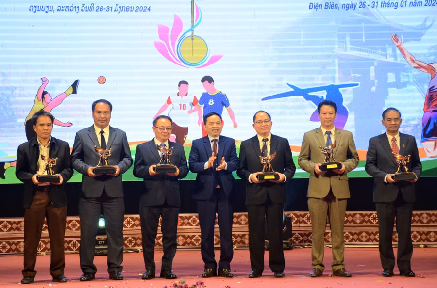 Ông Nguyễn Văn Đoạt, Giám đốc Sở GD&amp;ĐT Điện Biên (đứng giữa) tặng quà lưu niệm cho Sở Giáo dục và Thể thao 6 tỉnh Bắc Lào.