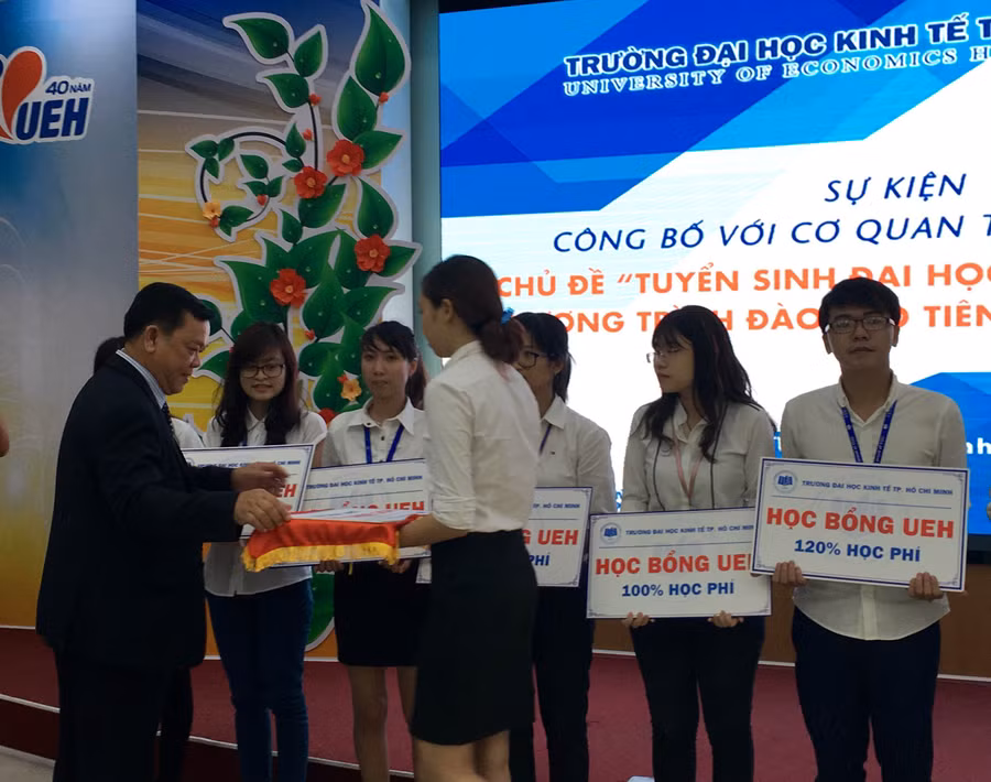 GS Nguyễn Đông Phong - Hiệu trưởng UEH - trao học bổng cho sinh viên tại lễ công bố chuyển đổi chương trình đào tạo