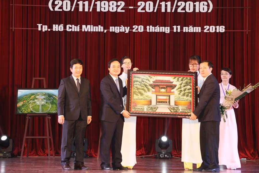Bộ trưởng Bộ GD&ĐT Phùng Xuân Nhạ (trái) tặng quà chúc mừng cho Ban Giám đốc Đại học Quốc gia TPHCM Bộ trưởng Bộ GD&ĐT Phùng Xuân Nhạ (trái) tặng quà chúc mừng cho Ban Giám đốc Đại học Quốc gia TPHCM