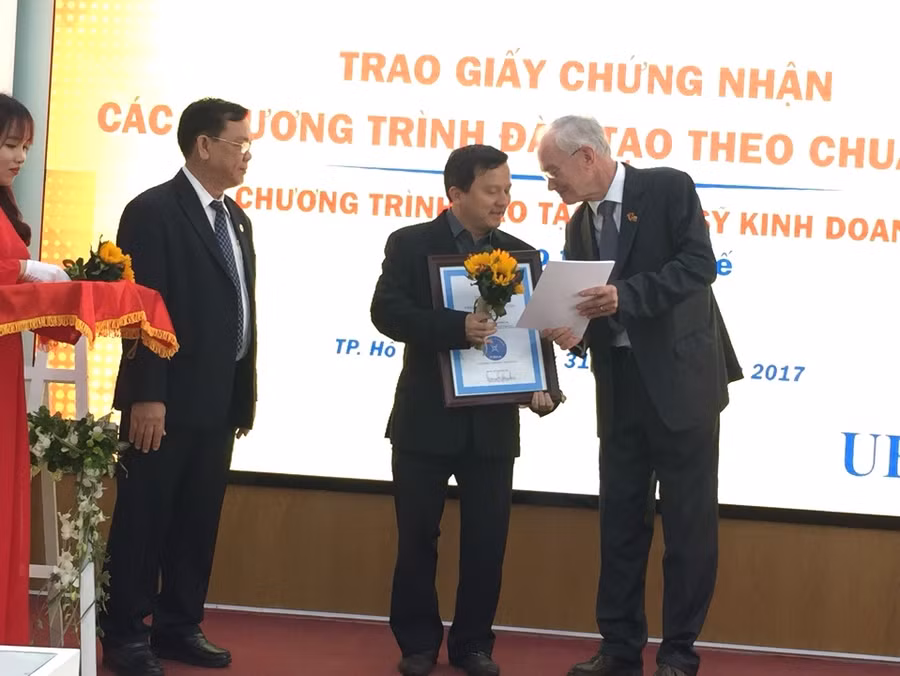 Đại diện của tổ chức kiểm định FIBAA (bên phải) trao giấy chứng nhận kiểm định cho các chương trình đạt chuẩn của UEH
