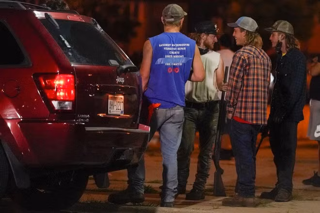 Một nhóm người cầm súng trường quan sát người biểu tình trên đường phố Kenosha, bang Wisconsin, hôm 25/8. Ảnh: AP.