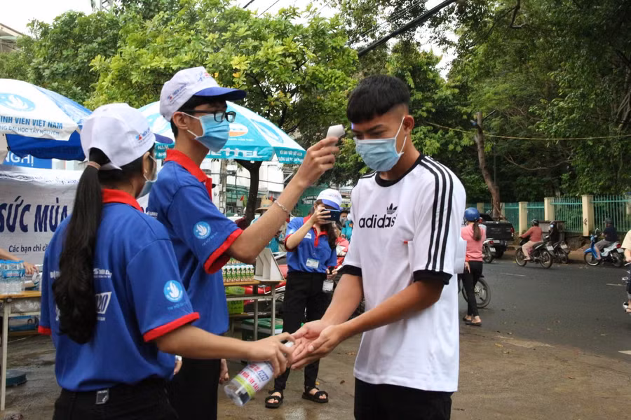 Thí sinh được đo thân nhiệt, sát khuẩn trước khi vào điểm thi.