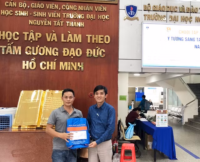 Thạc sĩ Nguyễn Bá Anh (bên phải) trao biểu trưng ba lô và học bổng cho đại diện của Báo Giáo dục & Thời đại