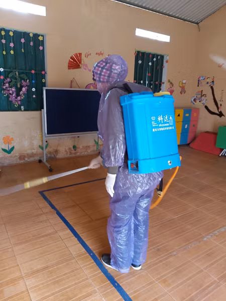 Nhiều người ảnh hưởng vì học sinh nghỉ kéo dài ảnh 1 Cô giáo ở điểm trường xã Sủng Là, Đồng Văn, Hà Giang mặc áo mưa, đeo khẩu trang khử trùng lớp học. Ảnh: Phạm Phương Hồng.