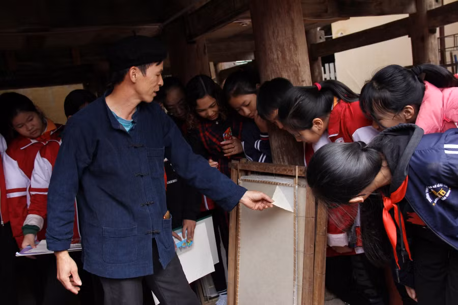 Anh Dương Văn Quang giới thiệu cho HS về các công đoạn làm giấy dó. Ảnh: TG.