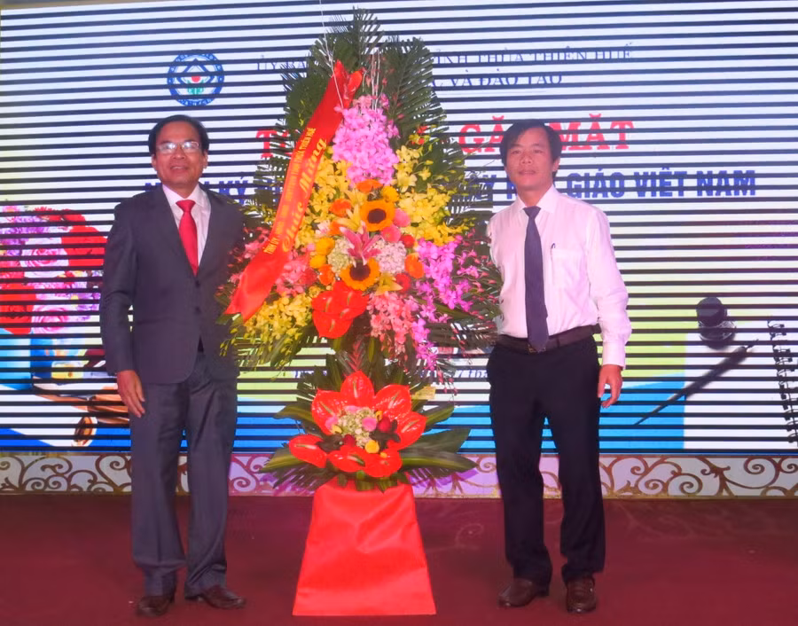 Ông Nguyễn Văn Phương ( áo trắng) – Phó chủ tịch UBND tỉnh Thừa Thiên Huế tặng hoa chúc mừng cán bộ, giáo viên nhân ngày 20-11