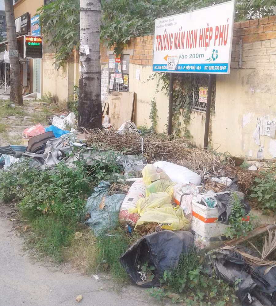 Bãi rác tự phát ngay dưới tấm biển chỉ lối vào trường học