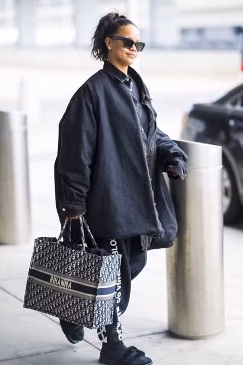 Rihanna sở hữu túi xách Dior Book Tote với họa tiết Oblique với tên của cô được dệt trên túi.