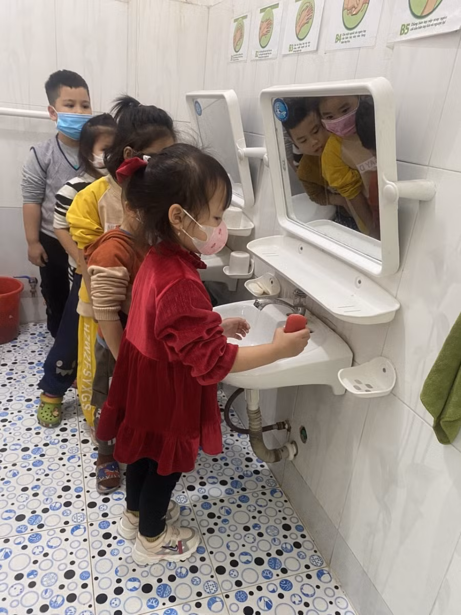 Trẻ được hướng dẫn đi rửa tay bằng xà phòng trước giờ ăn cơm trưa.
