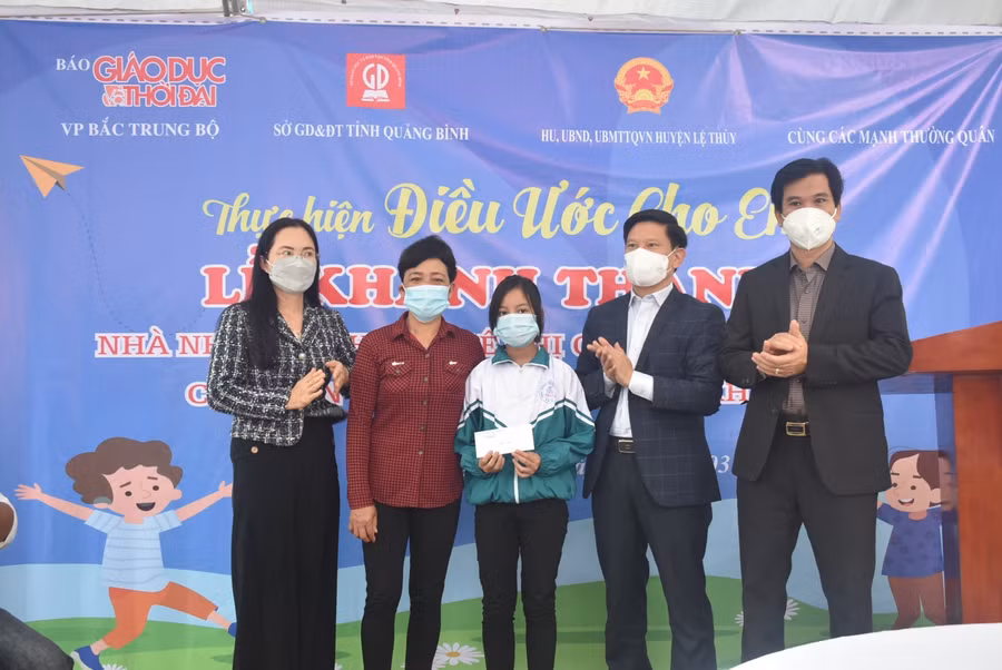Đại diện lãnh đạo huyện Lệ Thủy tặng quà hỗ trợ học sinh Lê Thị Quỳnh Hoa.