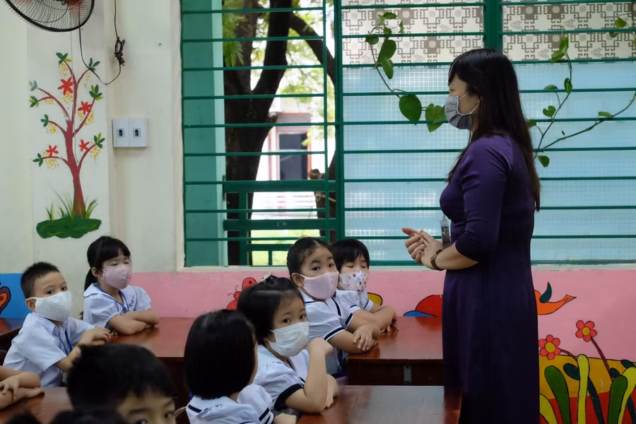 Các giáo viên hướng dẫn các học sinh khi vào học.