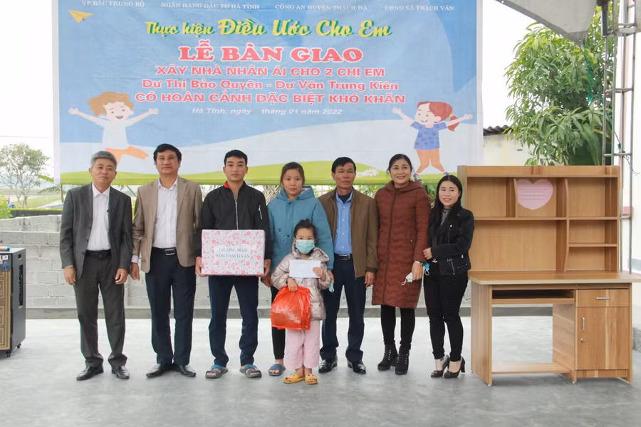 Lãnh đạo Phòng Giáo dục và Đào tạo huyện Thạch Hà, các trường học tại xã Thạch Văn trao quà cho gia đình hai cháu tại lễ bàn giao nhà mới