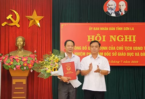 Ông Cầm Văn An (bên trái) nhận Quyết định và hoa chúc mừng