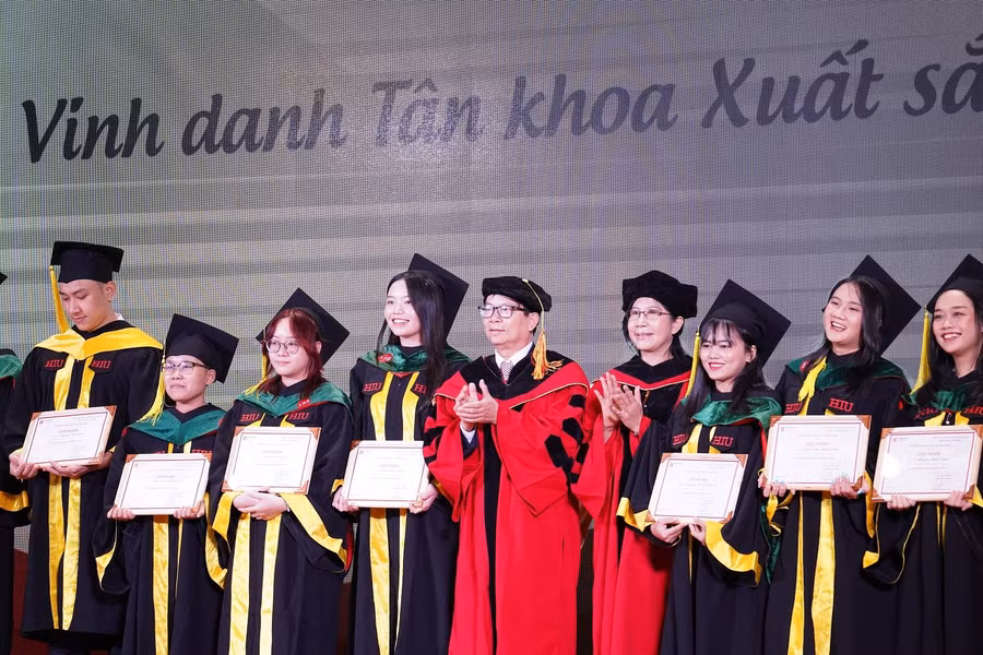 PGS.TS Lê Khắc Cường (áo đỏ, đứng giữa) Phó hiệu Trưởng HIU vinh danh các tân khoa xuất sắc trong buổi lễ tốt nghiệp.