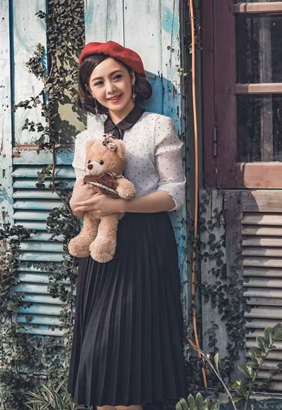 Diễn viên mặc theo phong cách cổ điển với sơ mi cổ Peter Pan, chân váy xếp ly và mũ beret. Diễn viên trẻ thanh lịch khi ăn mặc theo phong cách cổ điển với sơ mi cổ Peter Pan, chân váy xếp ly và mũ beret.
