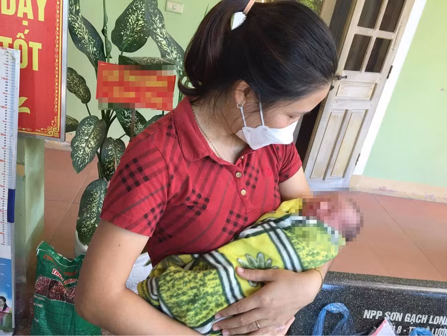 Người dân chăm sóc bé trai bị bỏ rơi ở khu đô thị Vườn Xanh (huyện Đô Lương, Nghệ An).