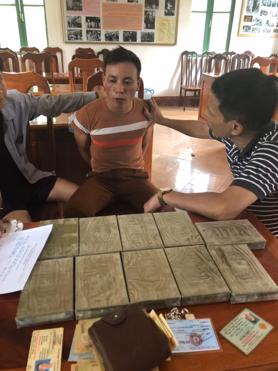Đối tượng Phàn Vần Páo (ngồi giữa) cùng tang vật