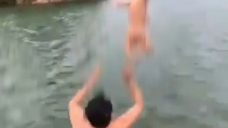 Bố ném thẳng con từ trên vai xuống hồ để dạy bơi 
