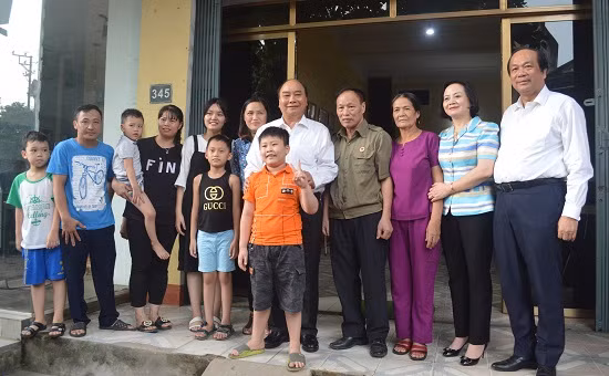 Thủ tướng Nguyễn Xuân Phúc thăm, tặng quà và chụp ảnh lưu niệm cùng gia đình ông Phạm Văn Tín, thương binh hạng 1/4 tại tổ 6, phường Yên Ninh (Ảnh Cổng TTĐT YB)