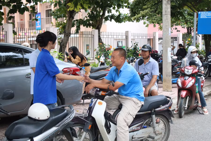 Lực lượng tình nguyện hỗ trợ phát nước, quạt miễn phí cho phụ huynh tại các điểm thi.