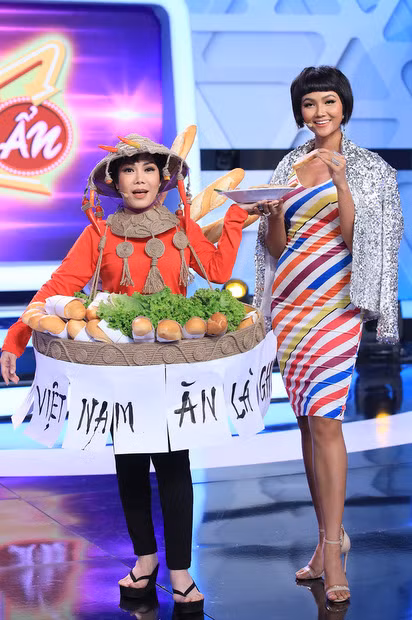 Diễn viên Việt Hương (trái) diễn hài trong thiết kế giống váy "Bánh mỳ" của H"Hen Niê.