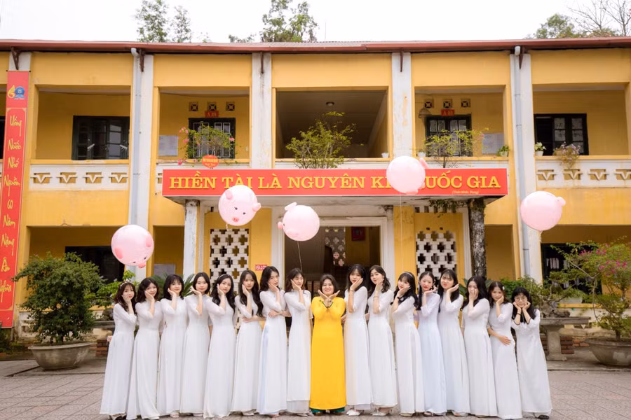 Cô Hoa (áo vàng, đứng giữa) chụp ảnh lưu niệm cùng học sinh.