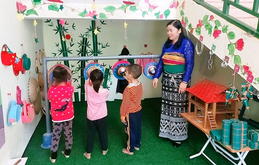Cô Vi Thị Vinh hướng dẫn học sinh tập chơi đánh chiêng.