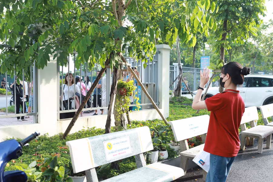 Con gái vẫy tay chào tạm biệt mẹ để bước vào khu vực thi.