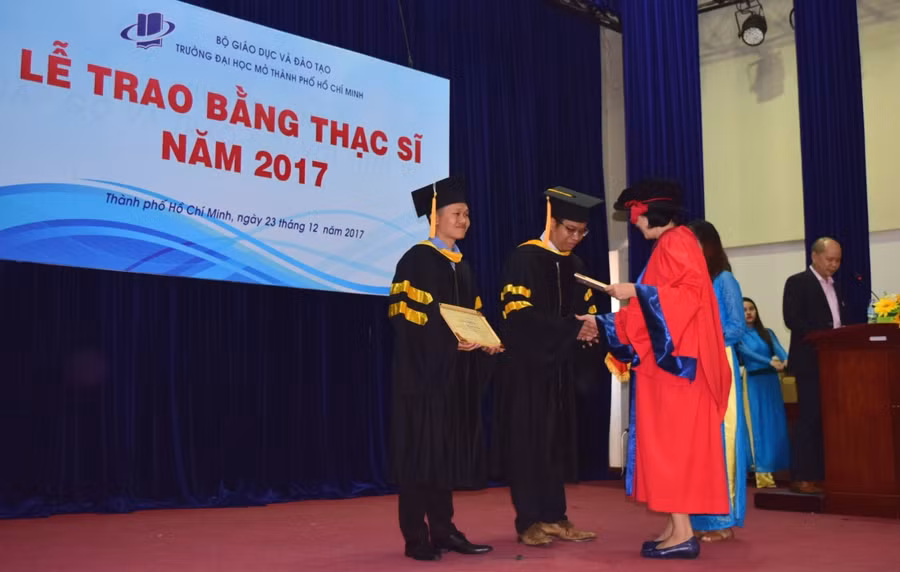 Đại diện một khoa lên trao bằng tốt nghiệp cho học viên