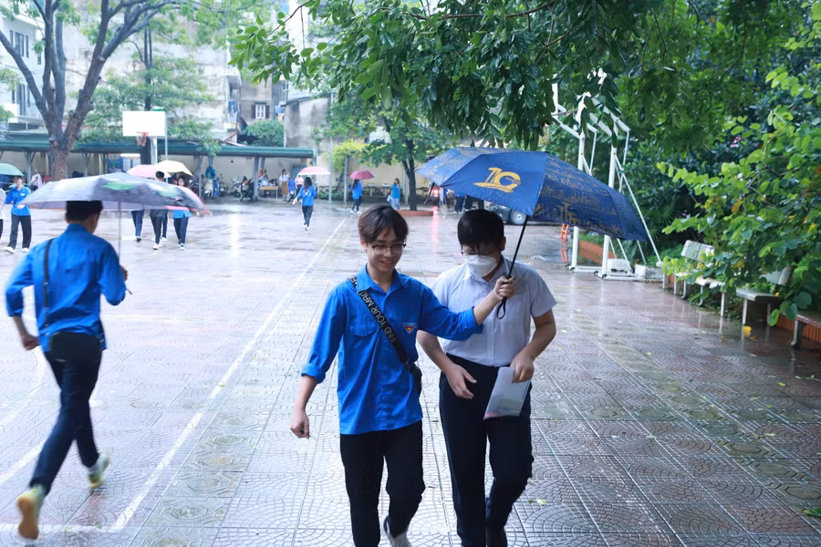 Lực lượng thanh niên thay nhau cầm ô che mưa cho thí sinh. Lực lượng thanh niên thay nhau cầm ô che mưa cho thí sinh.