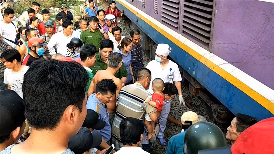 Lực lượng cứu hộ cùng rất nhiều người dân hỗ trợ đưa nạn nhân ra khỏi gầm tàu hỏa. Ảnh: T.S