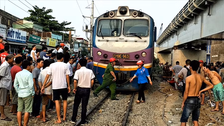 Đoàn tàu dừng lại để các lực lượng chức năng cứu hộ nạn nhân thoát chết hy hữu khi bị tàu hỏa cuốn vào gầm chiều nay. Ảnh: T.S