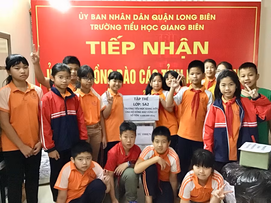 Các em học sinh trường Tiểu học Giang Biên hưởng ứng đợt vận động quyên góp, ủng hộ đồng bào lũ lụt miền Trung.