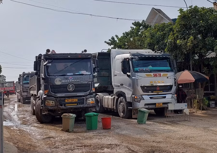 Người dân xã Minh Nghĩa mang đồ chặn xe tải. (Ảnh: NT).