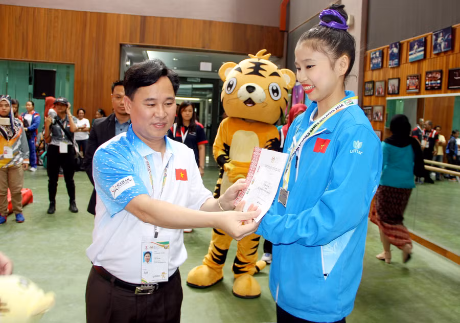 Ông Lê Mạnh Hùng - Phó Vụ trưởng Vụ Giáo dục Thể chất - Trưởng đoàn thể thao học sinh Việt Nam tặng huy chương và giấy chứng nhận cho các vận động viên thể dục giành chuy chương
