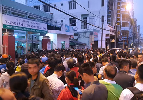 Người dân xếp hàng từ đêm đến sáng 28/3 để chờ lấy phiếu tiêm dịch vụ cho con. Ảnh: Tấn Việt.