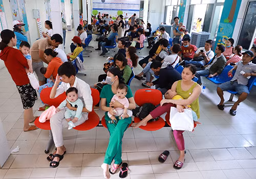 Đến gần trưa, hàng chục phụ huynh vẫn còn lán lại với hy vọng sớm đăng ký tiêm dịch vụ cho con. Ảnh: Nguyễn Đông.